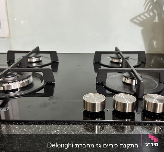 כיריים גז עם ארבעה מבערים וכפתורי שליטה
